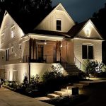 Custom home exterior at dusk with warm landscape lighting